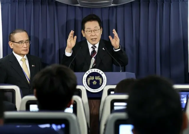 大統領専用機で記者団の取材に応じる李大統領＝（聯合ニュース）