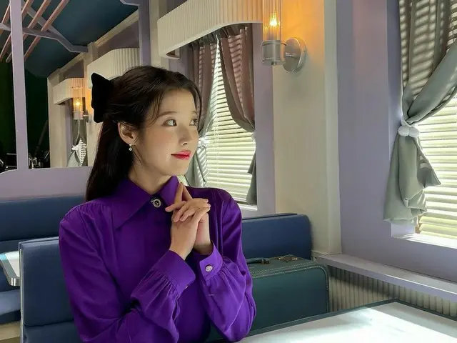 IU、パープルカラーのレトロな雰囲気のセット場で輝く美貌